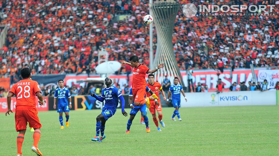 Pemain Persija Ismed Sofyan berebut bola lambung dengan pemain Persib, Makan Konate. 